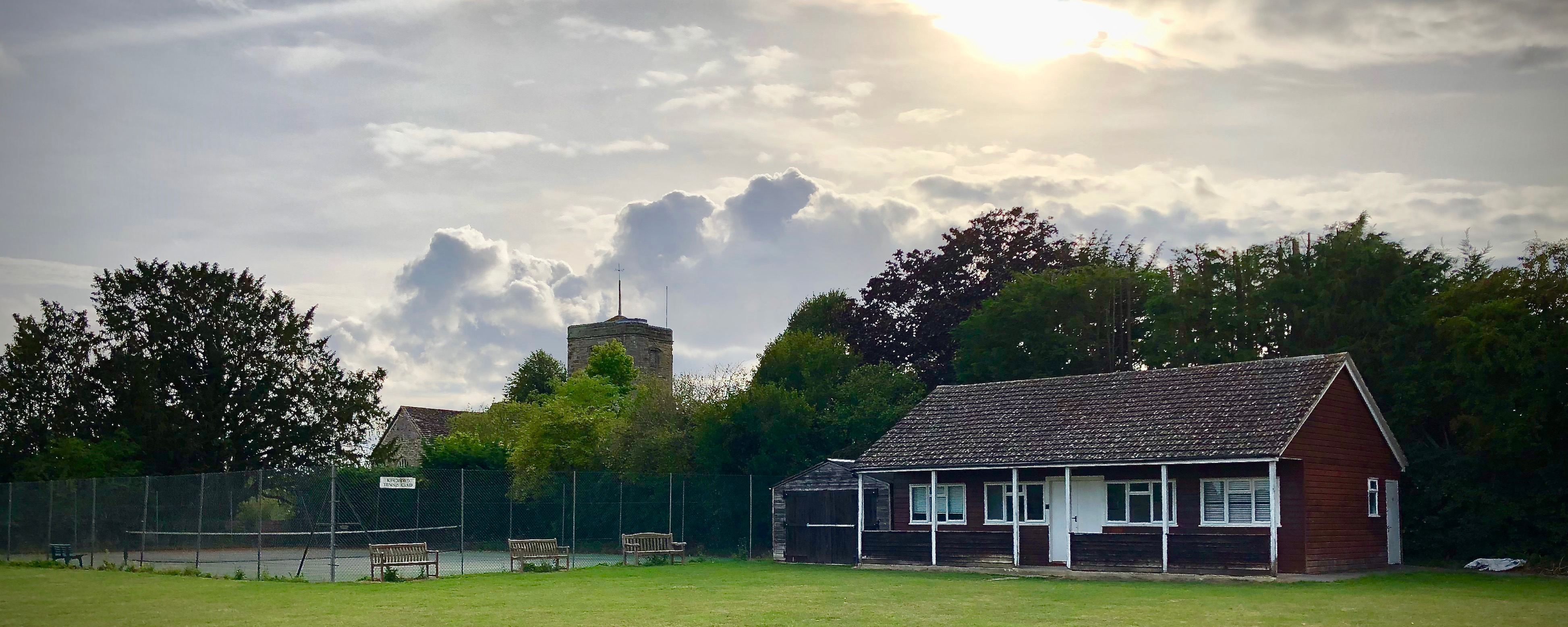 Kirdford Pavilion and tennis court, with church in the background